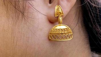 Close-up portrait of new design earring in girl's ears photo