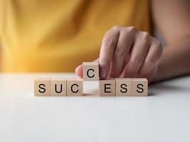 Businesswoman hold wooden cube with the word success on surface. Successful concept. photo
