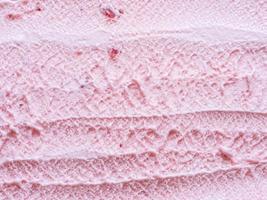 close up texture of a tasty strawberry ice cream scraped with a spoon photo