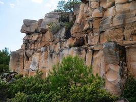 view on a wall of rocks on a mountain surrounded by trees photo