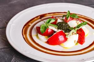 ensalada caprese con mozzarella, tomate, albahaca y pesto foto