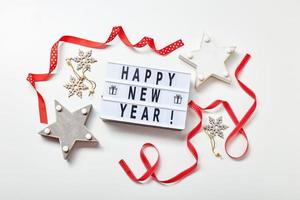 Light box inscription Happy New Year and wooden decorations photo