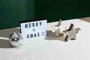 Light box inscription Merry Xmas and wooden ornaments photo