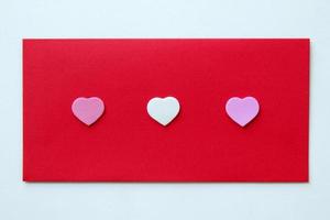 The red envelope with three hearts for Valentine's Day. photo