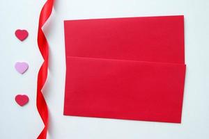 Two red envelopes with three hearts and ribbon for Valentine's Day. photo