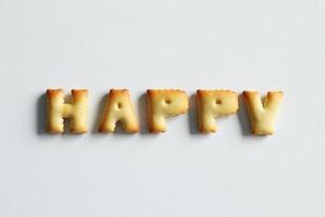 An inscription from the cookies on the white background. Text - happy. photo