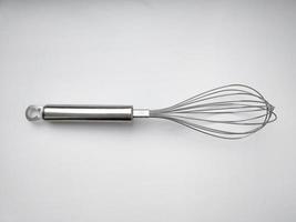 Stainless steel whisk on white background. Kitchen utensil photo