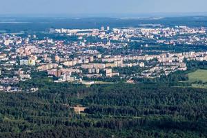 ariel panoramic view of city and skyscrapers with a huge factory with smoking chimneys in the background photo