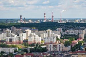 ariel panoramic view of city and skyscrapers with a huge factory with smoking chimneys in the background photo