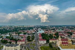 vista panorámica aérea desde gran altura sobre los tejados rojos de la antigua gran ciudad con rascacielos y nubes blancas esponjosas foto