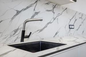 Black water tap sink with faucet in expensive kitchen photo