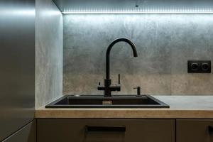 Black water tap sink with faucet in expensive kitchen photo