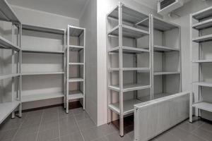 rows of metal shelves in fridge wardrobe. refrigerator for storing large amounts of food photo