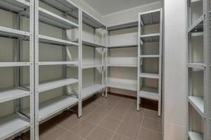 rows of metal shelves in fridge wardrobe. refrigerator for storing large amounts of food photo