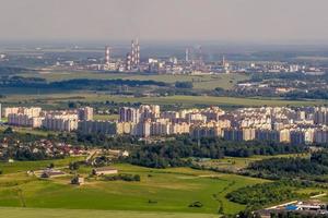 ariel panoramic view of city and skyscrapers with a huge factory with smoking chimneys in the background photo