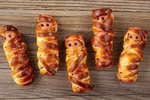 Scary sausage mummies in dough for kids party. Funny crazy Halloween food for children. photo