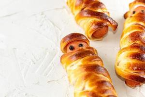 Scary sausage mummies in dough for kids party. Funny crazy Halloween food for children. photo