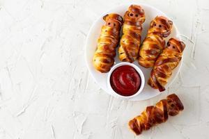 Scary sausage mummies in dough for kids party. Funny crazy Halloween food for children. photo