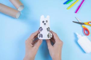 Festive easy DIY craft for children. Roll of toilet paper toy bear on a blue background. Creative decoration eco friendly, reuse, recycling, minimal waste free handmade concept photo