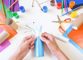 paso 3. diy conejo de papel de un rollo de papel higiénico. artesanía fácil para niños sobre fondo blanco, idea simple de bricolaje del tubo del inodoro, concepto de reciclaje. foto