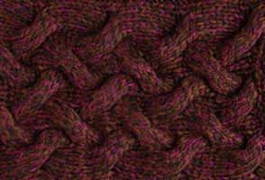 Texture of smooth knitted dark sweater with pattern. Top view, close-up. Handmade knitting wool or cotton fabric texture. Background of knitting patterns with a vertical large Braid Cable. photo