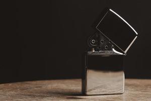 primer plano de un encendedor en una mesa de madera con fundamento negro foto