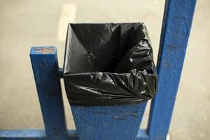 Urn with bag. Place for garbage. Trash can with black bag. Public garbage on street. photo