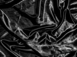 Black cloth or fabric exture background with liquid wave or wavy folds. Wallpaper design photo