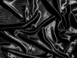 Black cloth or fabric exture background with liquid wave or wavy folds. Wallpaper design photo