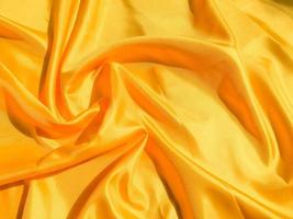 Beautiful yellow silk or satin texture background with copy space for design and artwork photo