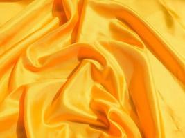 Bright yellow silk with waves moving for background. Abstract design with copy space photo