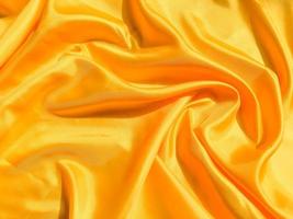 Bright yellow silk with waves moving for background. Abstract design with copy space photo