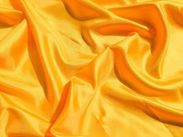 Bright yellow silk with waves moving for background. Abstract design with copy space photo