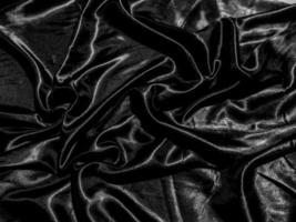 fondo de seda negra de lujo o textura satinada con ondas líquidas o pliegues ondulados. diseño de papel tapiz foto