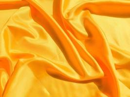 Bright yellow silk with waves moving for background. Abstract design with copy space photo