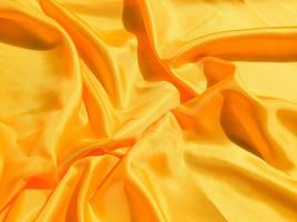 Bright yellow silk with waves moving for background. Abstract design with copy space photo