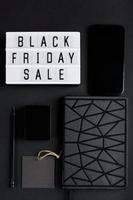 Black Friday sale. Smartphone and accessories on dark background. Monochromatic flatlay, online shopping concept. photo