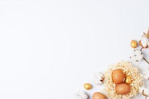 Nest with easter eggs with flowers on white background. Flat lay, copy space photo