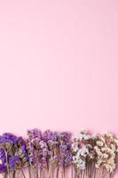 Cosmetic background with flowers on pink. Flat lay, copy space photo