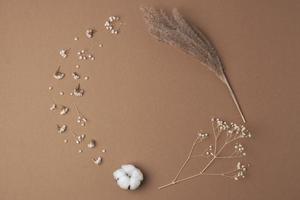 Cosmetic background with flowers on brown. Flat lay, copy space photo