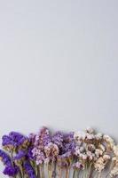 Cosmetic background with flowers on grey. Flat lay, copy space photo