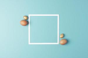 Easter beige and golden eggs on blue background with white frame. Flat lay, copy space. photo