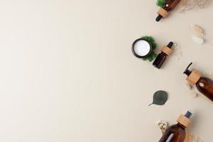 Skin care products on pastel beige background with moss, flowers. Flat lay, copy space. photo