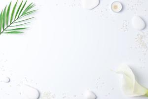 Spa background with white stones, candles, palm leaf and white flower on white. Flat lay,copy space photo