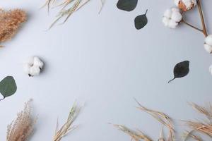 Cosmetic background with flowers on grey. Flat lay, copy space photo