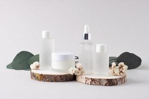 Cosmetic skin care products with eucalyptus and wood on grey background. Close up photo