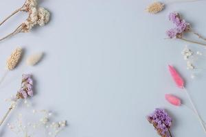 Cosmetic background with flowers on grey. Flat lay, copy space photo