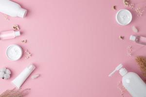 fondo cosmético con productos para el cuidado de la piel en rosa. endecha plana, espacio de copia foto