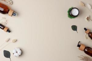 Skin care products on pastel beige background with moss, flowers. Flat lay, copy space. photo