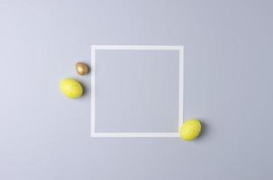 Easter yellow eggs with white frame on white background. Flat lay, copy space. photo